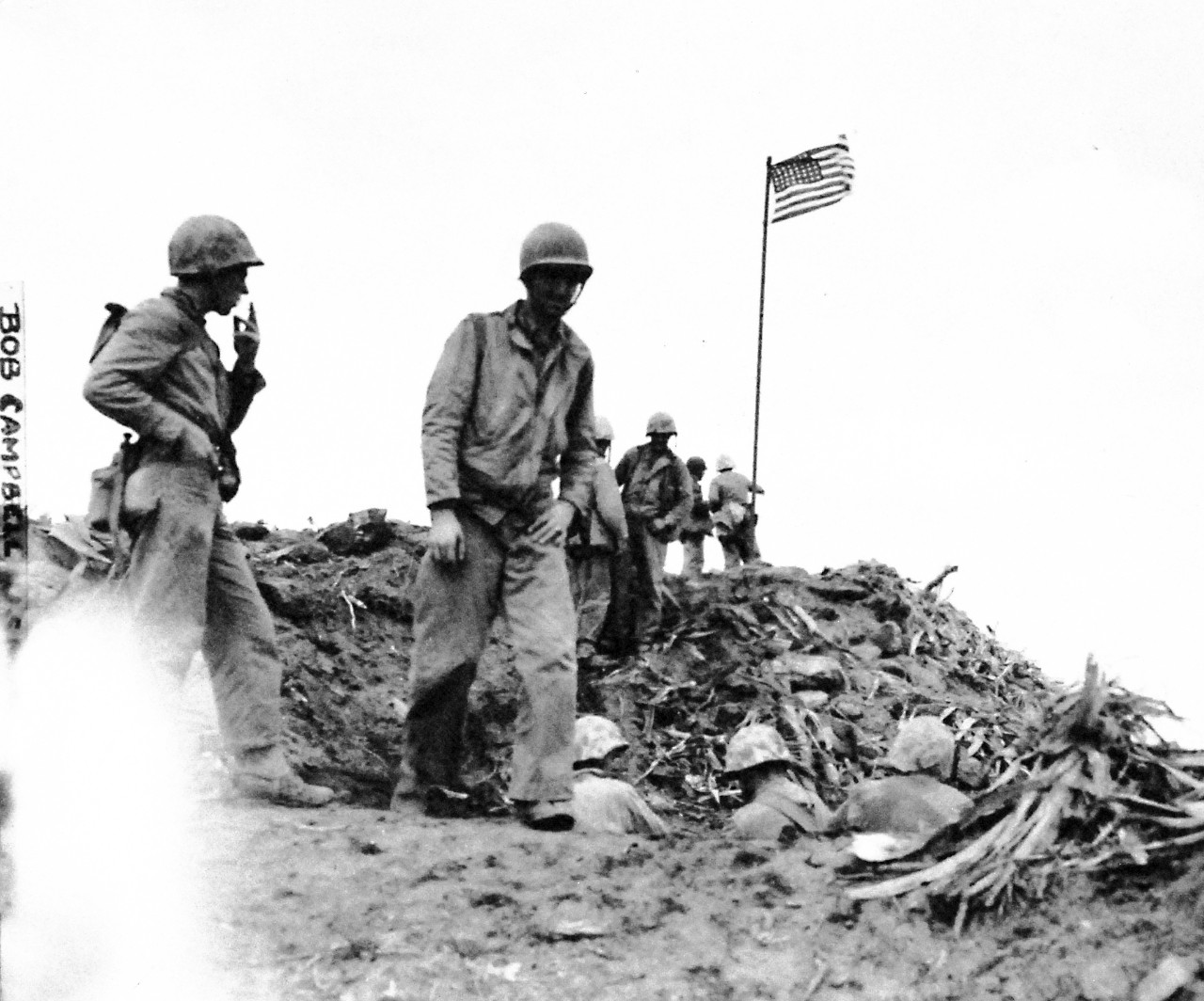 127-GW-319-112715:   Iwo Jima Operations,  February 1945.  Group by the flag raised on Mount Surbachi by Marines of the Fifth Marine Division.   Photographed by Bob Campbell, February 23, 1945.   Official U.S. Marine Corps Photograph, now in the collections of the National Archives.  (2016/09/06).