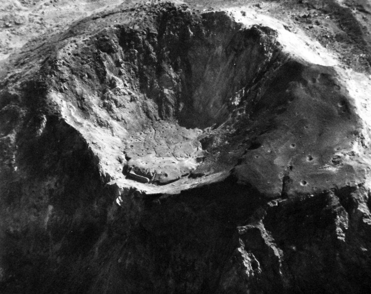 80-G-307201: Battle for Iwo Jima, February 27, 1945. Mt. Suribachi looking into cone following severe bombing by carrier-based planes of U.S. invasion fleet.  View is from South to North.   Photographed by plane from USS Saginaw Bay (CVE-82).    U.S. Navy photograph, now in the collections of the National Archives.  (2016/09/06).