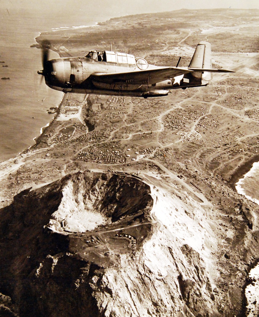 80-G-412543:  Battle for Iwo Jima, March 1945.  TBM aircraft flying over Mt. Suribachi shortly after Iwo Jima was secured.   Photographed by the Steichen Photograph Unit, March 1945.  TR-13268.  Official U.S. Navy Photograph, now in the collections of the National Archives.  (2018/02/14). 