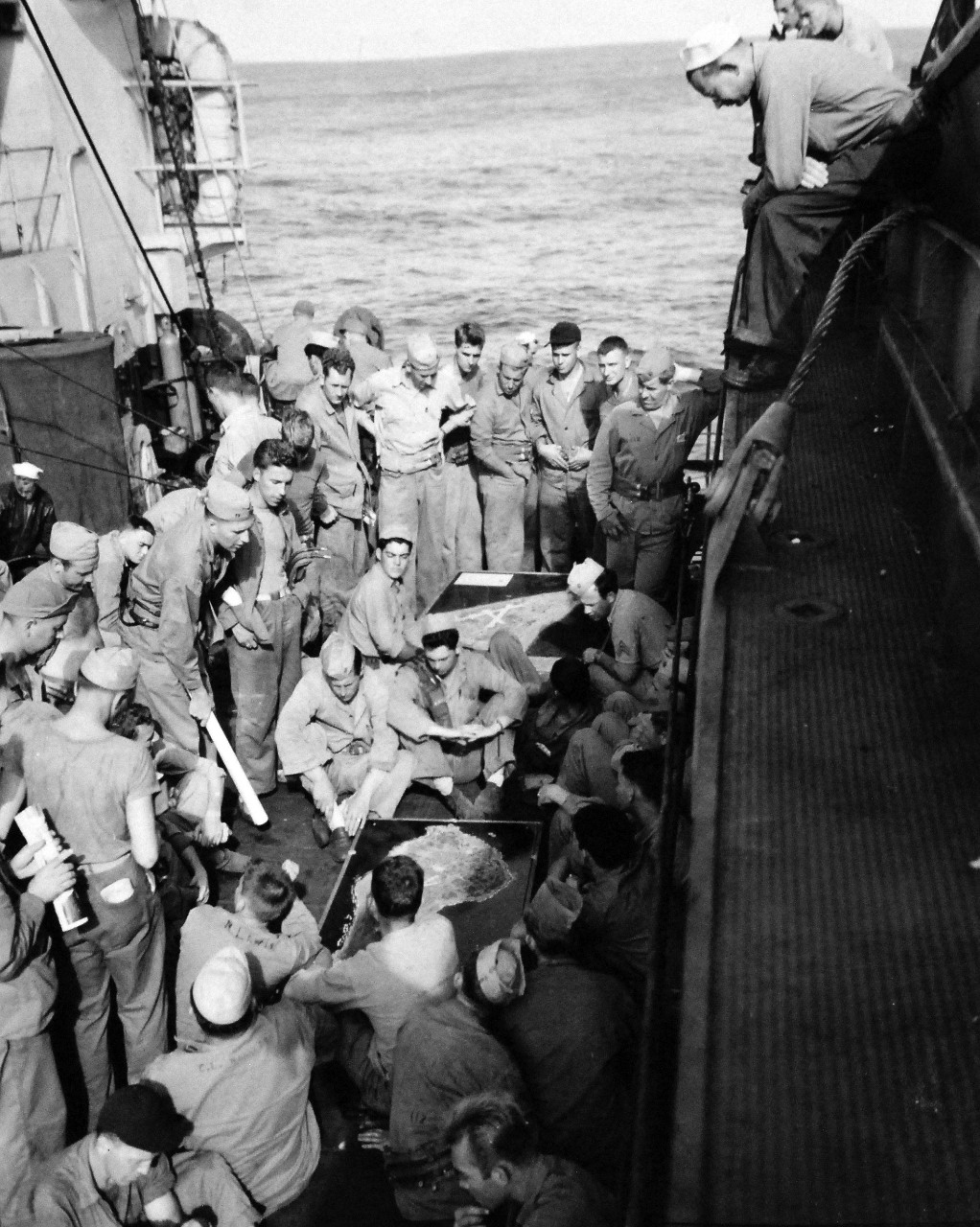 127-GW-302-109423:  Battle for Iwo Jima, February-March 1945.   A briefing class on the target of the troops is held by Captain K. Chandler on board ships, the men were told what their target was as soon as they sailed.    Photographed by Dodds onboard USS Cecil (APA-96), February 2, 1945.  Official U.S. Marine Corps photograph, now in the collections of the National Archives.  (2016/02/17).
