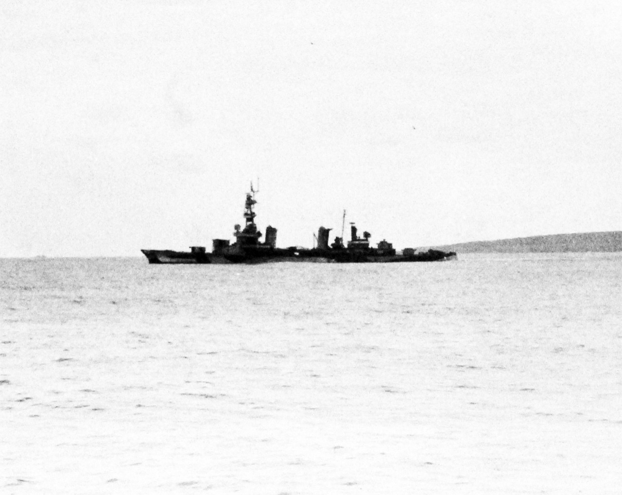 80-G-305000:  Battle for Iwo Jima, February 17, 1945.  USS Pensacola (CA-24) showing damage.  Seen from USS Heywood L. Edwards (DD-663), February 1945. On 17 February, Pensacola took six hits from enemy shore batteries as her guns covered operations of the minesweepers close inshore. Three of her officers and 14 men were killed. Another five officers and 114 men were injured.  Official U.S. Navy photograph, now in the collections of the National Archives.  (2016/09/06).