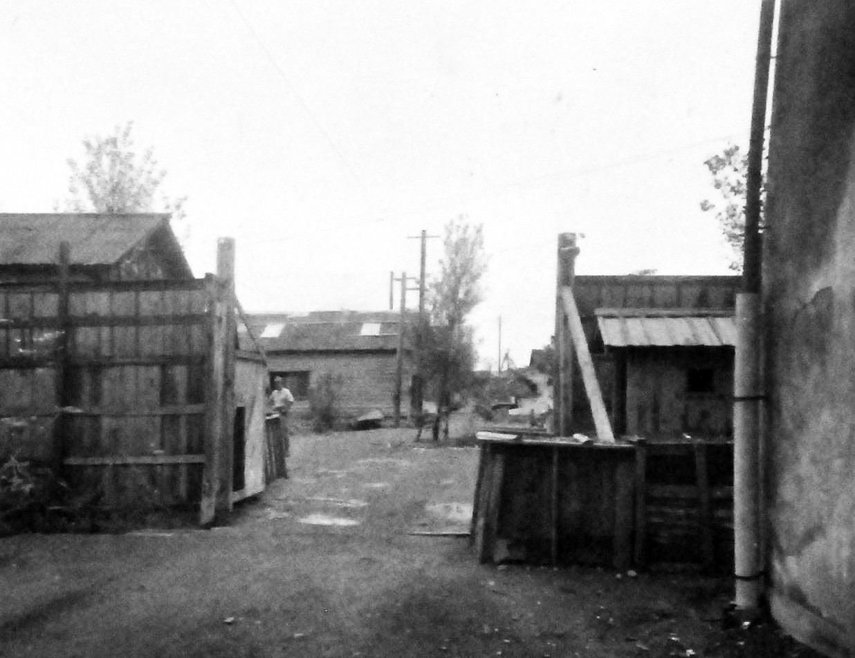 80-G-339282a:  Prisoner of War Camp, Omori Prison Camp, Toyko, Japan, 1945.      Shown here are some of the prisoner of war buildings, September 1, 1945.     Omori is one of Tokyo, Japan, biggest wards. Image taken by Ensign Simon and Photographer’s Mate Second Class Colb.   Official U.S. Navy photograph, now in the collection of the National Archives. (2013/08/14).    Note, the original photograph is about 1” x 1” in size.   