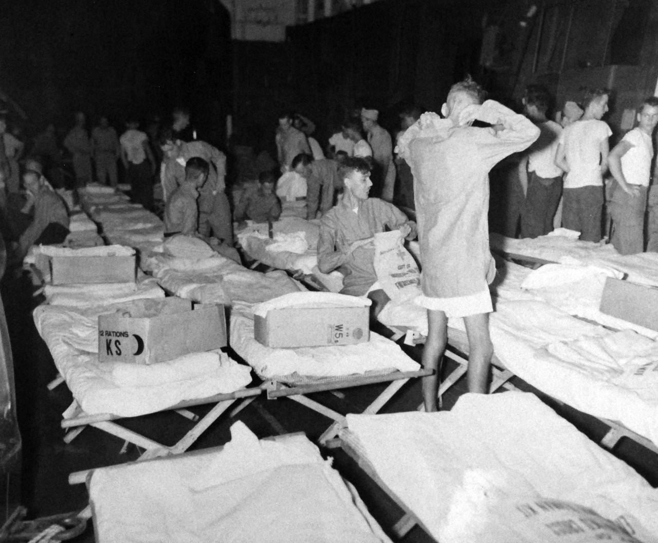 80-G-343551:    Allied Prisoner of War, Formosa, 1945.  Liberated British and Australian prisoners from a Formosan prison camp revel in clean clothes, cots, Red Cross kits, and a friendly welcome on board their rescue ship, USS Block Island (CVE 106).   Photographed by Photographer’s Mate First Class T.K. Brett, September 5, 1945.   Official U.S. Navy photograph, now in the collection of the National Archives.  (5/22/2014).   