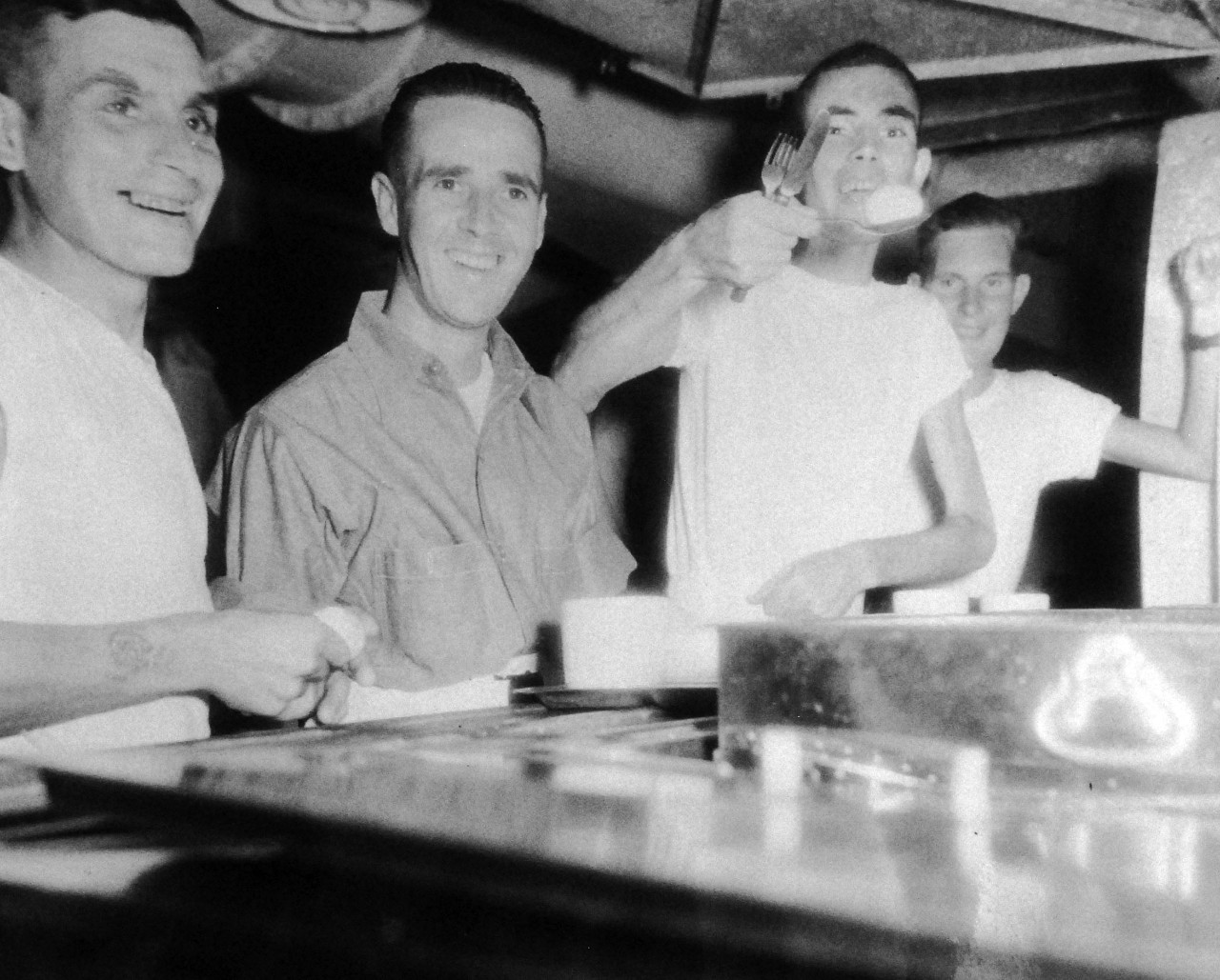 80-G-343559:    Allied Prisoners of War, 1945.   Liberated British and Australian prisoners from a Formosan prison camp get their first real meal on board USS Block Island (CVE-106) after three years confinement.   Photographed by Photographer’s Mate First Class T.K. Brett and Marine M. J. Kane (rank not given), September 5, 1945.   Official U.S. Navy photograph, now in the collection of the National Archives.  (2014/05/22).   The original photograph is small.   