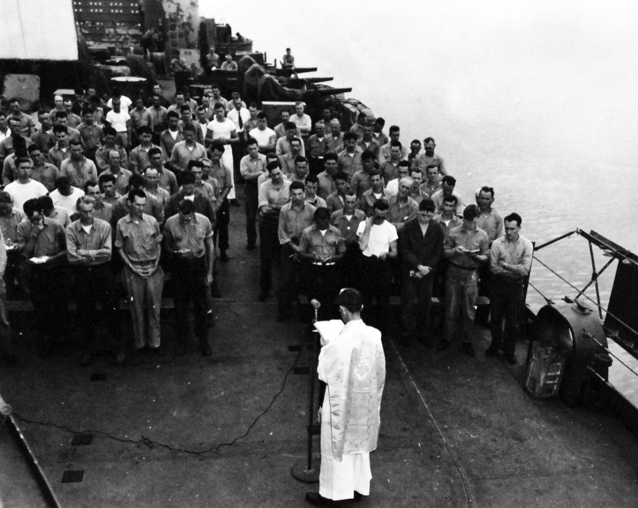 80-G-344561:  Allied Prisoners of War, 1945.    Major Albert W. Braun, U.S. Army Chaplain, holding divine services aboard ship.  Major Braun was captured by the Japanese at Corregidor on May 5, 1942, but the Japanese allowed him to conduct services in bath houses and Philippine natives helped getting altar supplies for him.  Photograph released September 24, 1945.  Official U.S. Navy photograph, now in the collections of the National Archives.   (2015/11/24).