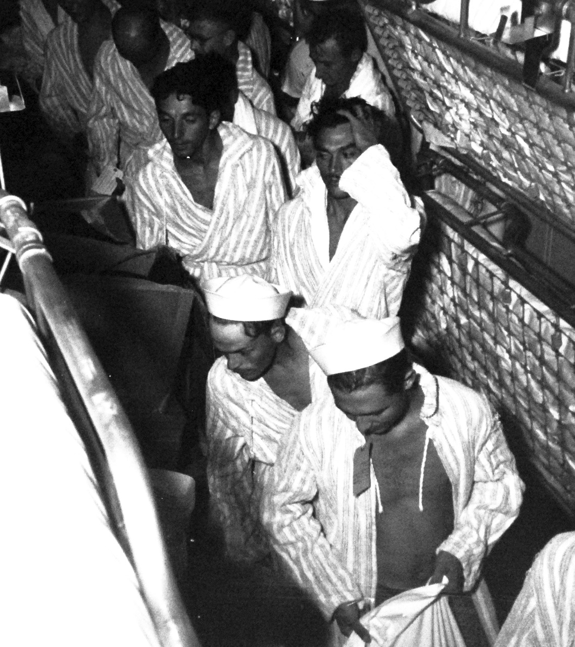 80-G-490453:  Allied Prisoners of War, 1945.   U.S.  Prisoners of War after their rescue from prison camps in the Tokyo area being cared for on board USS Benevolence (AH-13).  Rescued prisoners are given clothing, August 30, 1945.  Official U.S. Navy photograph, now in the collections of the National Archives.  (2014/05/29).    The original is a small photograph.   