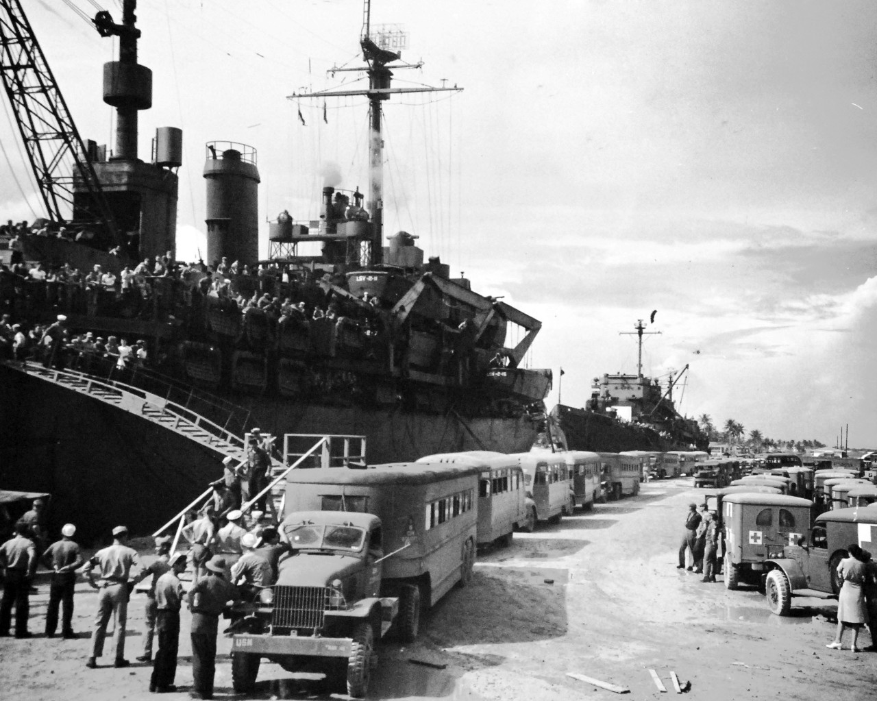 80-G-490495:   Allied Prisoners of War, 1945.   Sixty buses and ambulances line up to meet USS Ozark (LSV-2) when it arrived at Guam, Mariana Islands with 970 liberated Prisoners of War.   Photograph received September 1945.   Official U.S. Navy photograph, now in the collections of the National Archives.  (2014/05/29).    The original is a small photograph.   