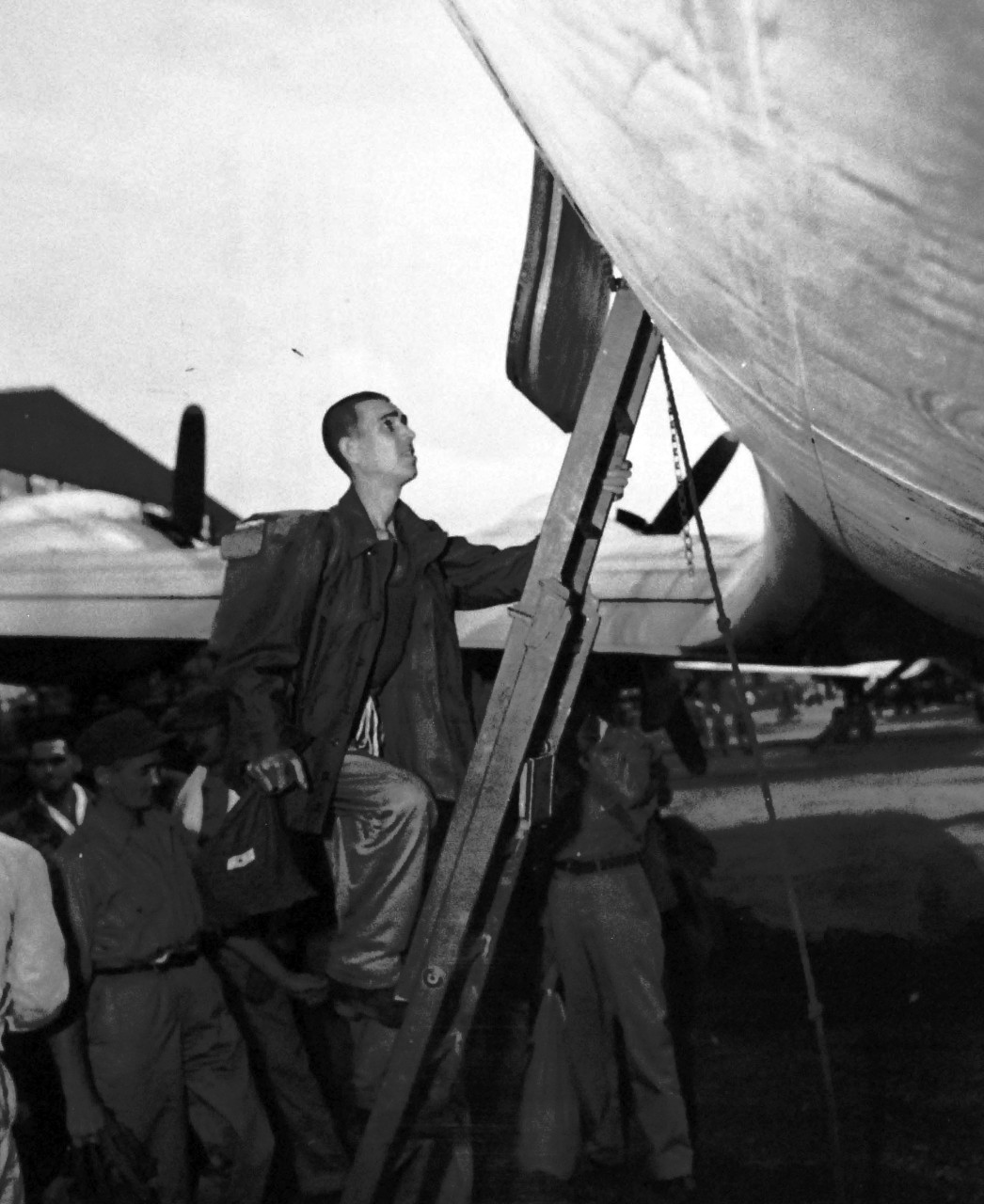 80-G-495641:  Prisoner of War Camp, Japan, 1945.    Former Prisoners of War preparing to leave Yokosuka, Japan, for the United States.  Prisoners of War aligning ladder to transport plane.   Photograph released September 19, 1945.  Official U.S. Navy photograph, now in the collections of the National Archives.  (2014/05/29).    The original is a small photograph.   