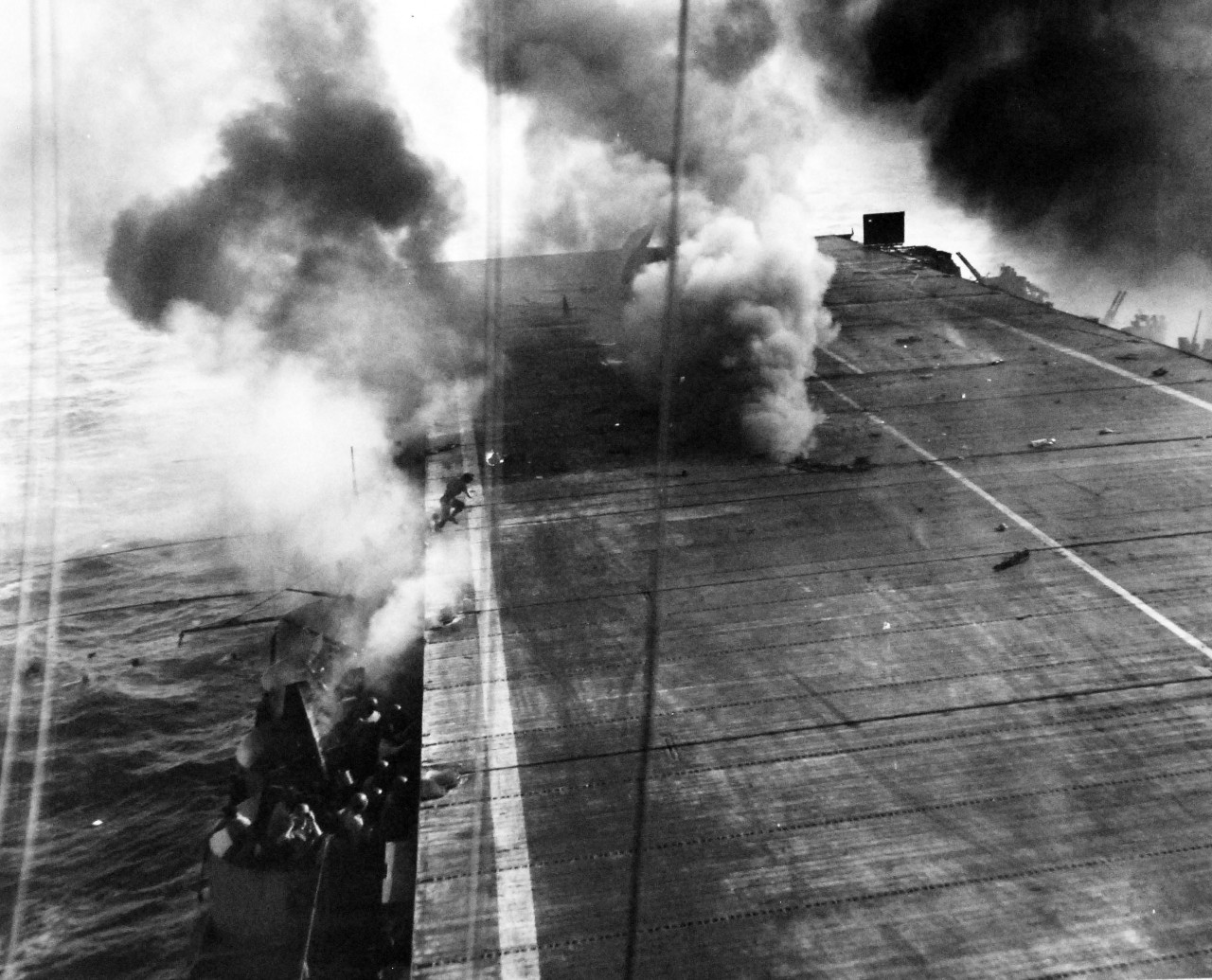 80-G-270662:   Battle off Samar, Japanese Kamikaze, October 25, 1944.   Japanese “Zero” crashes deck of USS Suwannee (CVE-27) and bursts into flames, Leyte Gulf, Philippines, 25 October 1944.   TBM may be seen in flight behind smoke.  This plane which was loaded with a torpedo was unharmed by the crash.  Official U.S. Navy Photograph, now in the collections of the National Archives.   (2014/4/24). 