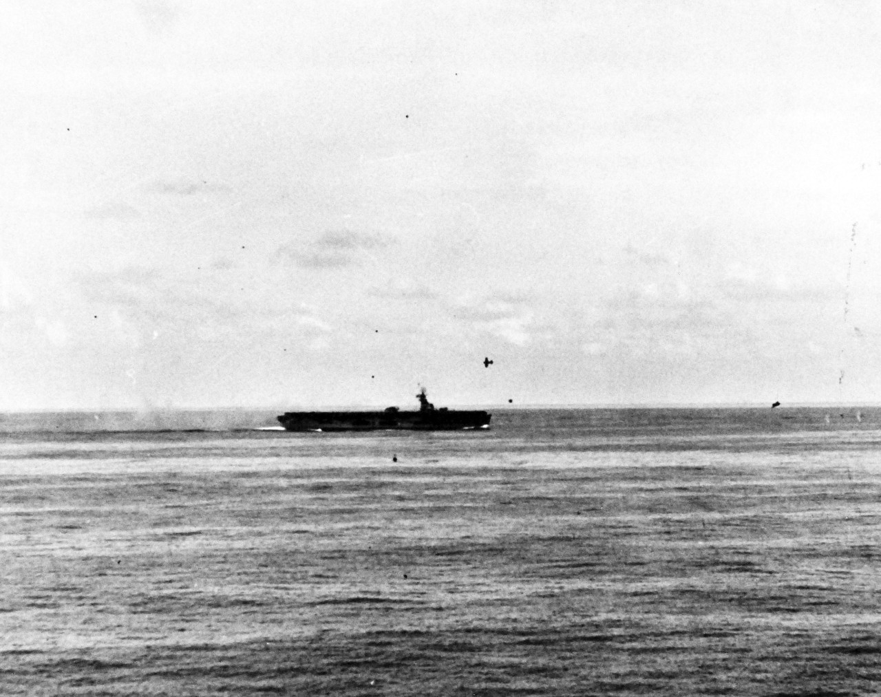 80-G-270665:  Battle off Samar, Japanese Kamikaze, October 25, 1944.   Two Japanese “Zero” aircraft making suicide attacks on USS Sangamon (CVE-266) off Leyte Gulf, Philippines, as seen from USS Suwannee (CVE- 27).  One Japanese near miss near bow.  Trailing Japanese turned away and was shot down by our fighters, 20 October 1944. Official U.S. Navy Photograph, now in the collections of the National Archives.   (2014/4/24). 
