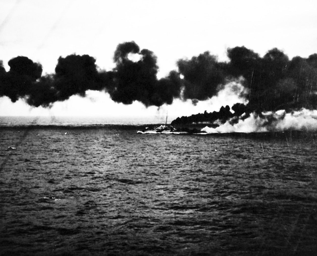 80-G-287459:   Battle off Samar, October 25, 1944.     Smoke laid by destroyers and destroyer escorts of US fleet provides screen from Japanese fleet during Battle of Leyte Gulf.   As seen from USS Kitkun Bay (CVE-71).  Shown is USS Dennis (DE-405).  Official U.S. Navy Photograph, now in the collections of the National Archives.  (2014/5/15).  