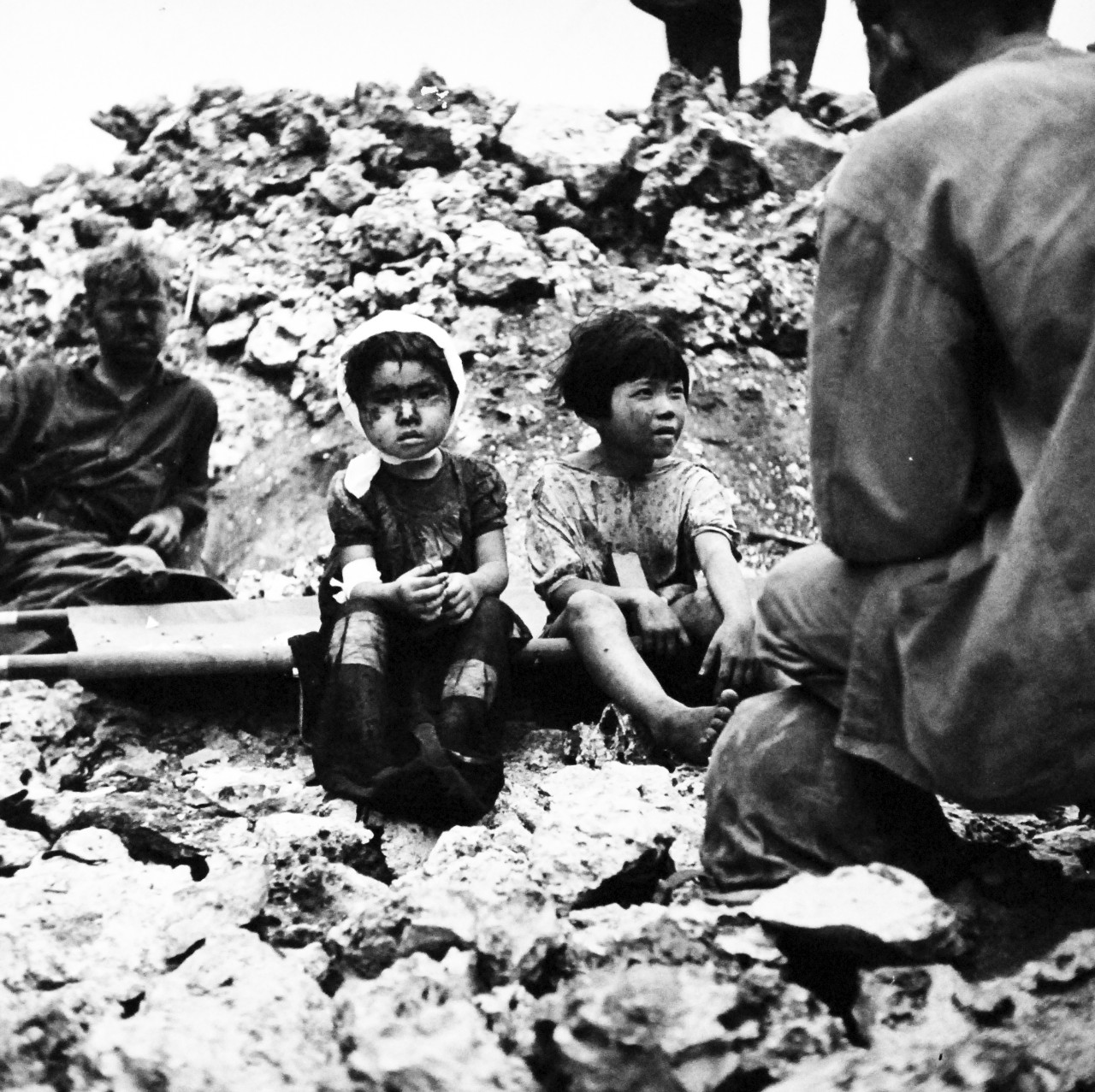 80-G-475136:  Invasion of Saipan, June-July 1944.  Two Japanese children answer questions of a U.S. Marine on Saipan.   Photographed by Lieutenant Paul Dorsey, July 1944, TR-10212.      Official U.S. Navy photograph, now in the collections of the National Archives.   (2017/03/15).
