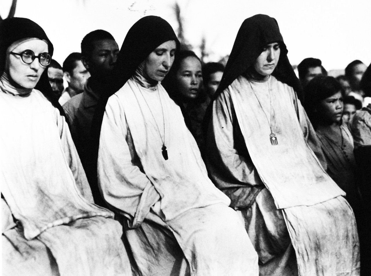 80-G-475144:  Invasion of Saipan, June-July 1944.  Catholic Nuns hear first mass on Saipan since 1940.  The Nuns were held captive by the Japanese.   Photographed by Lieutenant Paul Dorsey, July 1944, TR-10224.      Official U.S. Navy photograph, now in the collections of the National Archives.   (2017/03/15).
