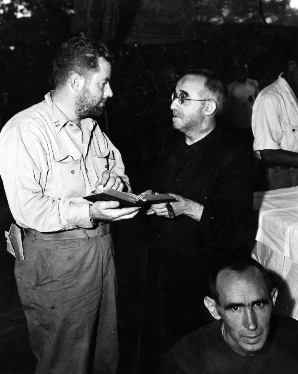 80-G-475145:  Invasion of Saipan, June-July 1944.  Catholic priest, (right), who escaped from the Japanese during Saipan during Saipan Campaign makes arrangements with the Marine Captain to say first Mass since 1940.  Photographed by Lieutenant Paul Dorsey, July 1944, TR-10225.      Official U.S. Navy photograph, now in the collections of the National Archives.   (2017/03/15).