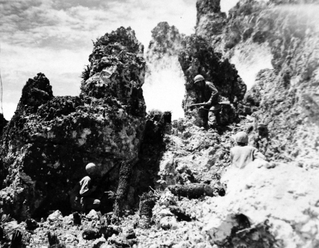 127-GW-518-124580:   Okinawa Campaign, April-June 1945.     “Pay Smoke”.  Three Marines of the 6th Division take a short pause in the day’s operations to smoke out the Japanese who might have been hiding in the hole behind the jagged coral boulder.  Camera caught the flash of the exploding smoke grenade, undated.   Official U.S. Navy Photograph, now in the collections of the National Archives.   (2014/6/25). 