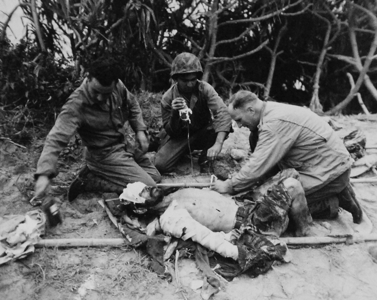 127-GW-666-128476:  Okinawa Campaign, April-June 1945.   Japanese prisoner being given blood plasma and first aid by Marines on Iheya Shima.  Photographed by Rogers, 3-5 June 1945.  Official U.S. Marine Photograph, now in the collection of the National Archives.  (2014/7/23). 