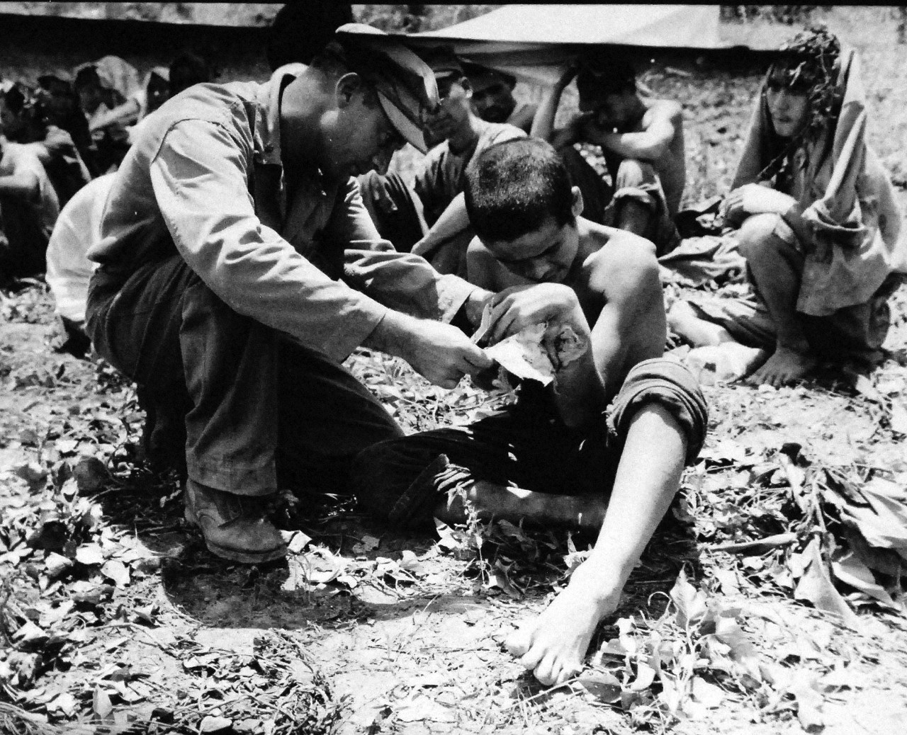 127-GW-666-128701:  Okinawa Campaign, April-June 1945.   Sixth Marine Division doctor bandages an arm wounded on a Japanese Prisoner of War taken in south of Okinawa, 1945.  Official U.S. Marine Photograph, now in the collection of the National Archives.  (2014/7/23). 