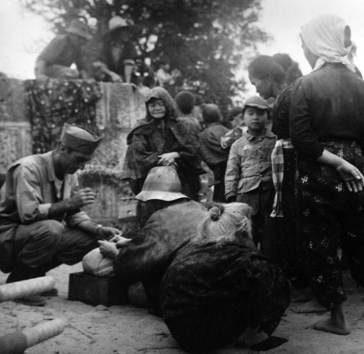 80-G-317100:   Okinawa Campaign, April-June 1945.  Natives of Okinawa at internment camp at Sobe, Okinawa.  They were holed up in a cave and brought out by the talking of a women already interned.   Photograph by Lieutenant Junior Grade A.B. Rickerby, released April 4, 1945.    Official U.S. Navy Photograph, now in the collections of the National Archives.  (2017/03/07).