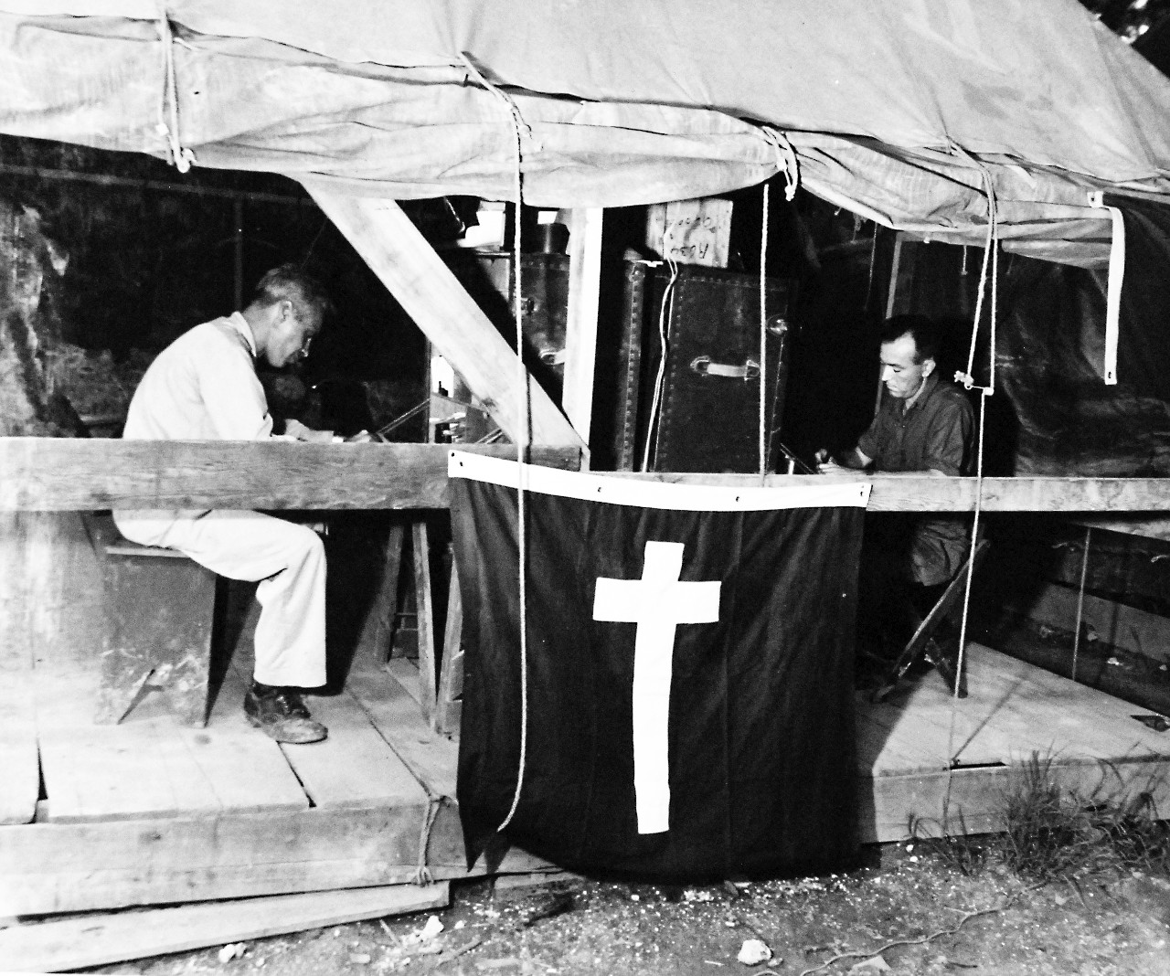 80-G-347081:  Okinawa, Ryukyus Islands  Chaplains, October 1945.   Chaplains, Lieutenant Commander O.G. Grotefend (with pipe in mouth) and Warrant Officer Leo Margulies, shown writing at their desk at Okinawa, Ryukyu Island.    Photograph received October 5, 1945.    Official U.S. Navy photograph, now in the collections of the National Archives.  (2017/02/14).  