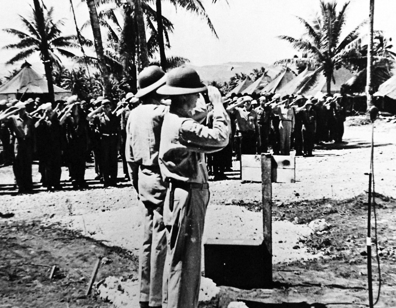 80-G-49595:  Okinawa Campaign, April-June 1945.  In foreground, commanding officer Captain J.M.C. Gordan and executive officer Commander E.F. Evans, MC, at formal flag raising ceremony on Okinawa during construction operations.    Photograph received June 29, 1945.   Official U.S. Navy photograph, now in the collections of the National Archives.  (2017/01/10).