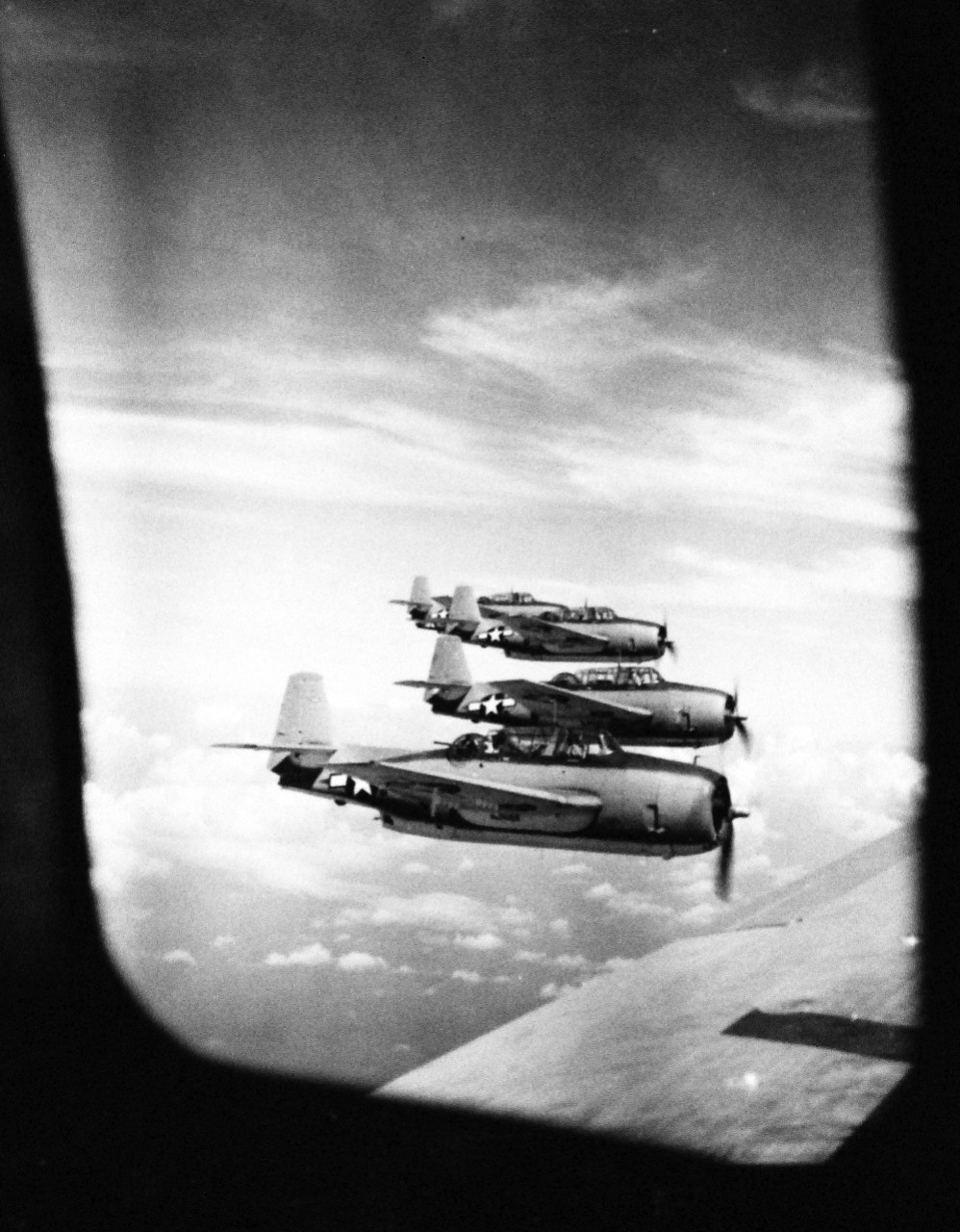 127-GW-530-121884:   Okinawa Campaign, U.S. Naval Gunfire Support, April-June 1945.  U.S. Marine Corps TBF “Avengers” over the Pacific.  Planes of a Marine torpedo bomber squadron seen through the escape hatch of a transport, en route to recently captured airfields on Okinawa.   Photographed by Master Sergeant C.L. Jansson, 25 April 1945.  Official U.S. Marine Corps Photograph, now in the collections of the National Archives.   (2014/6/25). 