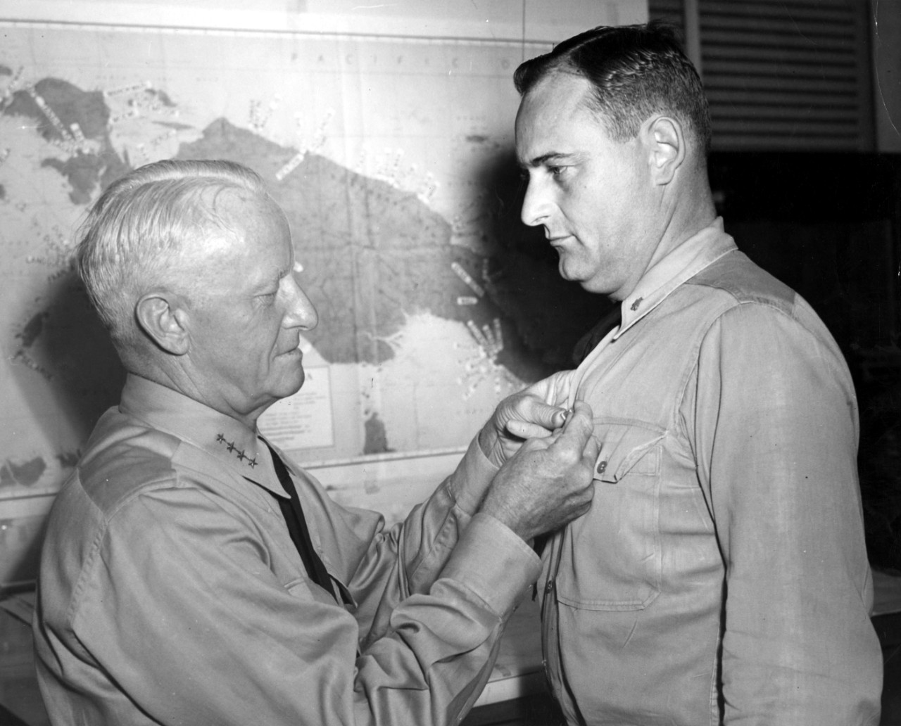 80-G-231835:  Commander T. R. Kurtz, Jr., receives the Navy Commendation Ribbon from Admiral Chester W. Nimitz, USN, at CINCPAC HQ, Pearl Harbor, June 26, 1944.    Commander Kurtz was the Navigator of USS Denver (CL-58) during operations in the Solomons in November 1943, and “contributed materially to the destruction of and damage to enemy ships, aircraft, and shore installations.”   Official U.S. Navy Photograph, now in the collection of the National Archives.  