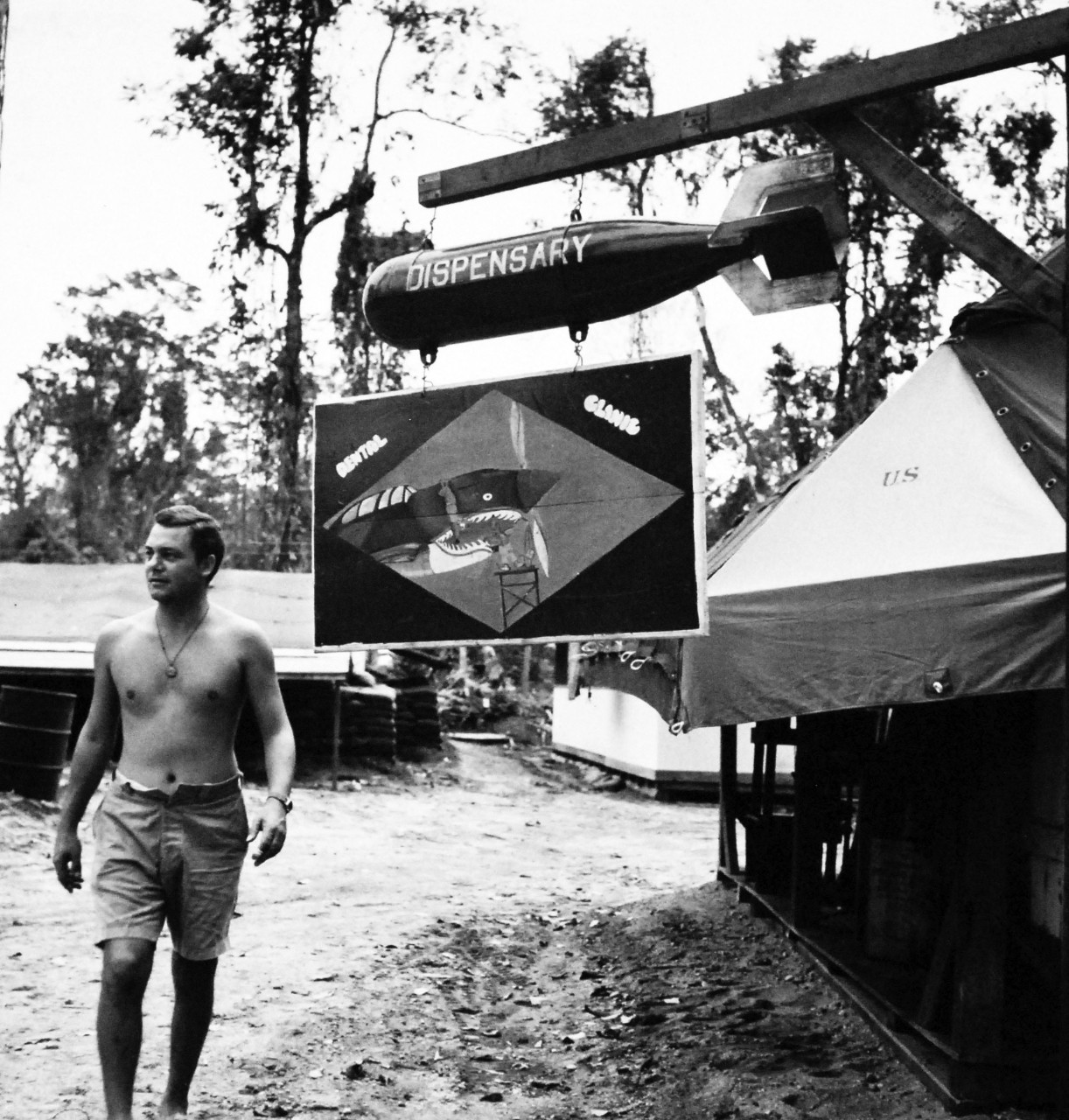 80-G-409035:  Bougainville Campaign, November 1943-August 1945.  As though prospect of the dentist wasn’t bad enough anyway, this sign is hung at the Dental Clinic at Bougainville.  The placard suspended from the water bomb depicts oral surgery being performed on a shark-nosed P-40 Army fighter.   Steichen Photograph crew, TR-9441, February 1944.   Official U.S Navy   Photograph, now in the collections of the National Archives.  (2017/12/13).
