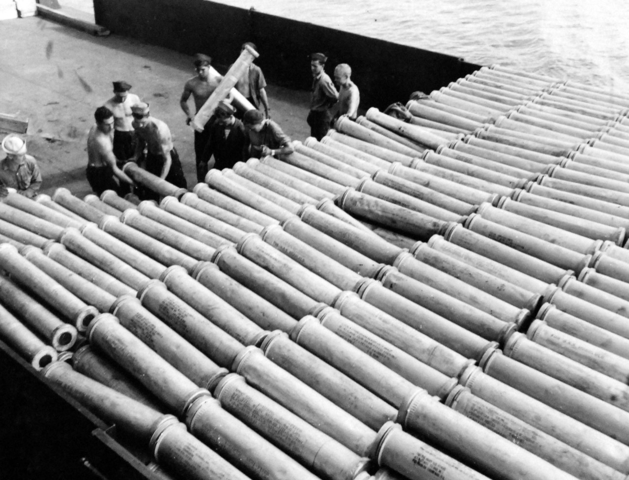 80-G-52883:  Battle of Kula Gulf, July 5-6, 1943.   USS Honolulu (CL-48), empty shell cases crowd the deck as the crew stacks cases.    Official U.S. Navy Photograph, now in the collections of the National Archives.  (2018/04/04).  