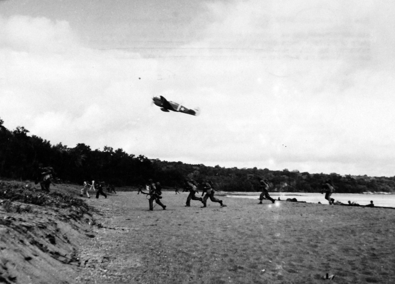 80-G-52782:   Rendova Island Invasion, June 30, 1943.  Landing craft debouch U.S. amphibious troops who run for the trees.   Overhead flying at “tree-top height” a USAAF P-40 provides air coverage.   Official U.S. Navy Photograph, now in the collections of the National Archives.  (2018/04/04). 