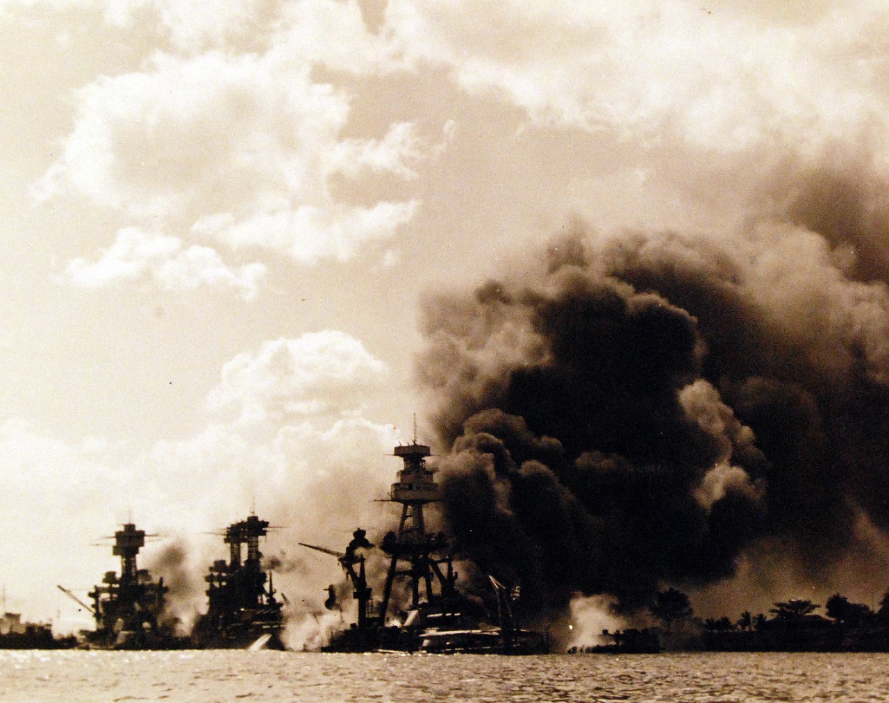 80-G-32421:  Pearl Harbor Attack, 7 December 1941.  View looking up "Battleship Row" on 7 December 1941, after the Japanese attack. USS Arizona (BB-39) is in the center, burning furiously. To the left of her are USS Tennessee (BB-43) and the sunken USS West Virginia (BB-48).  Similar to NH 97378. Official U.S. Navy photograph, now in the collections of the National Archives.     (9/15/15).