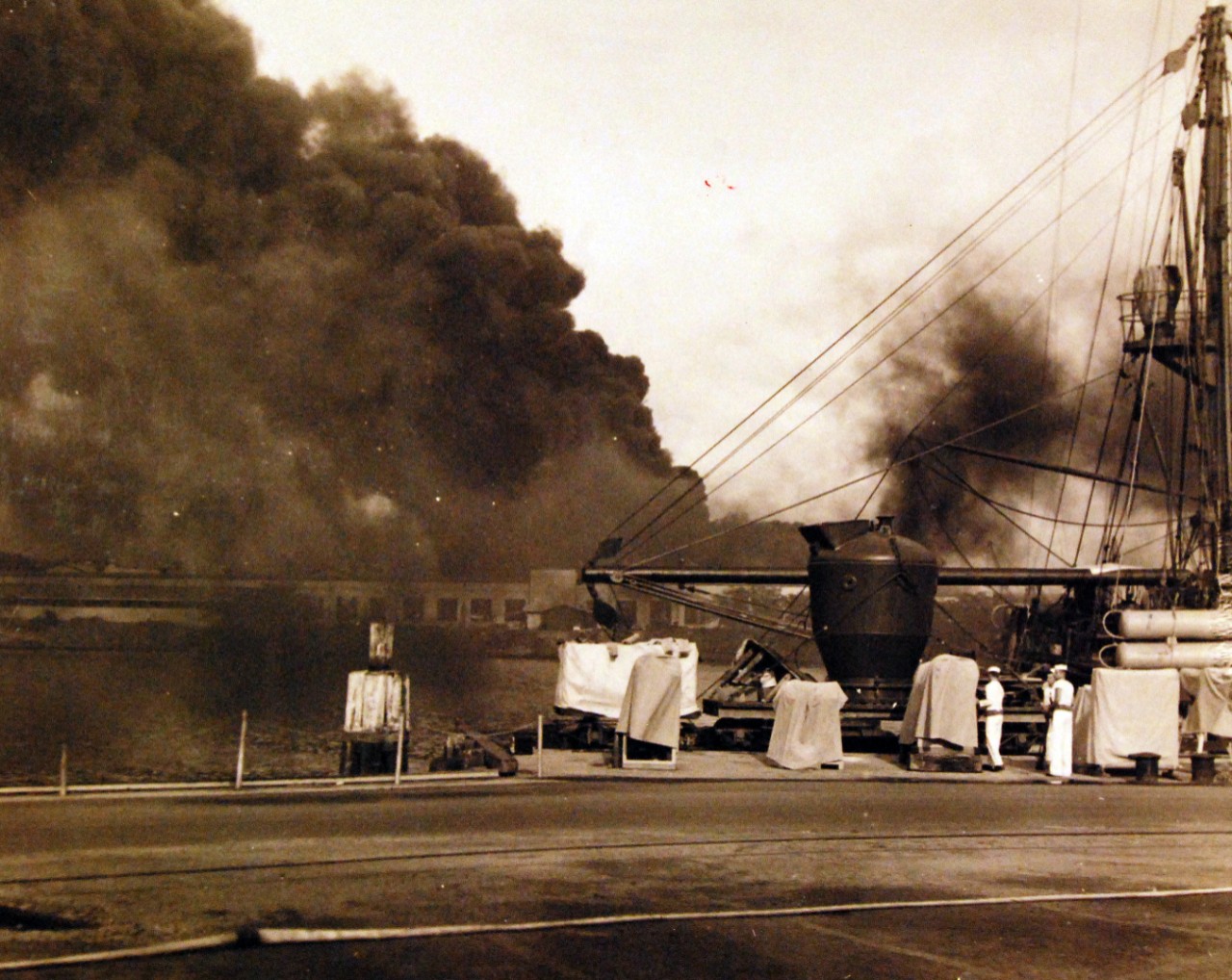 80-G-32728:   Japanese Attack on Pearl Harbor, December 7, 1941.   This view looks towards Magazine Island from the Submarine Base.  USS Widgeon (ASR 1) is in the foreground.  Smoke from the burning ships darkens the sky.   Official U.S. Navy photograph, now in the collections of the National Archives.             (9/9/2015).