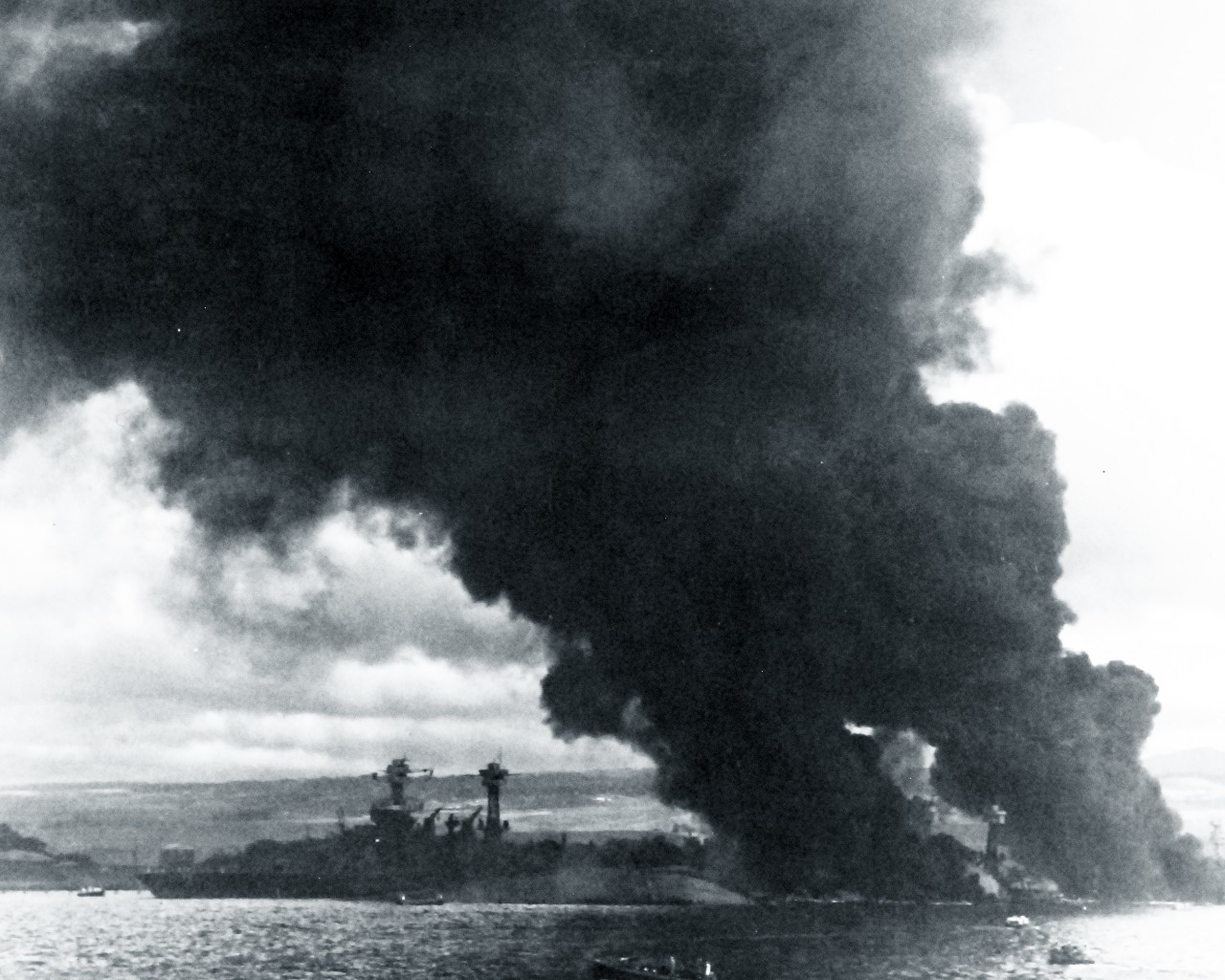 80-G-32921:   Japanese Attack on Pearl Harbor Attack, 7 December 1941.  USS Arizona (BB-39) is sunk and burning at right. USS West Virginia (BB-48) is in the right center, sunk alongside USS Tennessee (BB-43), with oil fires shrouding them both. Taken during or right after the Japanese Attack. U.S. Navy photograph, now in the collections of the National Archives.  (8/27/2013).