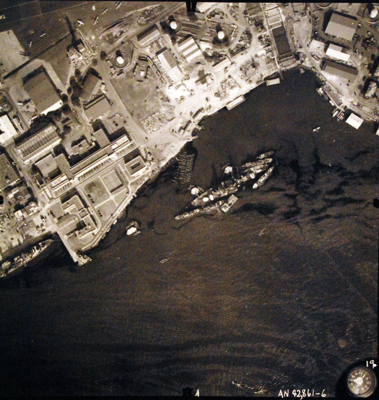 80-G-387567:  Pearl Harbor Attack, 7 December 1941.  Aerial view of "Battleship Row" moorings on the southern side of Ford Island, 10 December 1941, showing damage from the Japanese raid three days earlier.  USS California (BB 44) is shown.  Note dark oil streaks on the harbor surface, originating from the sunken battleships. Photographed by VJ-1 at an altitude of 3,000 feet and released November 9, 1950. U.S. Navy photograph, now in the collections of the National Archives   (9/22/2015).