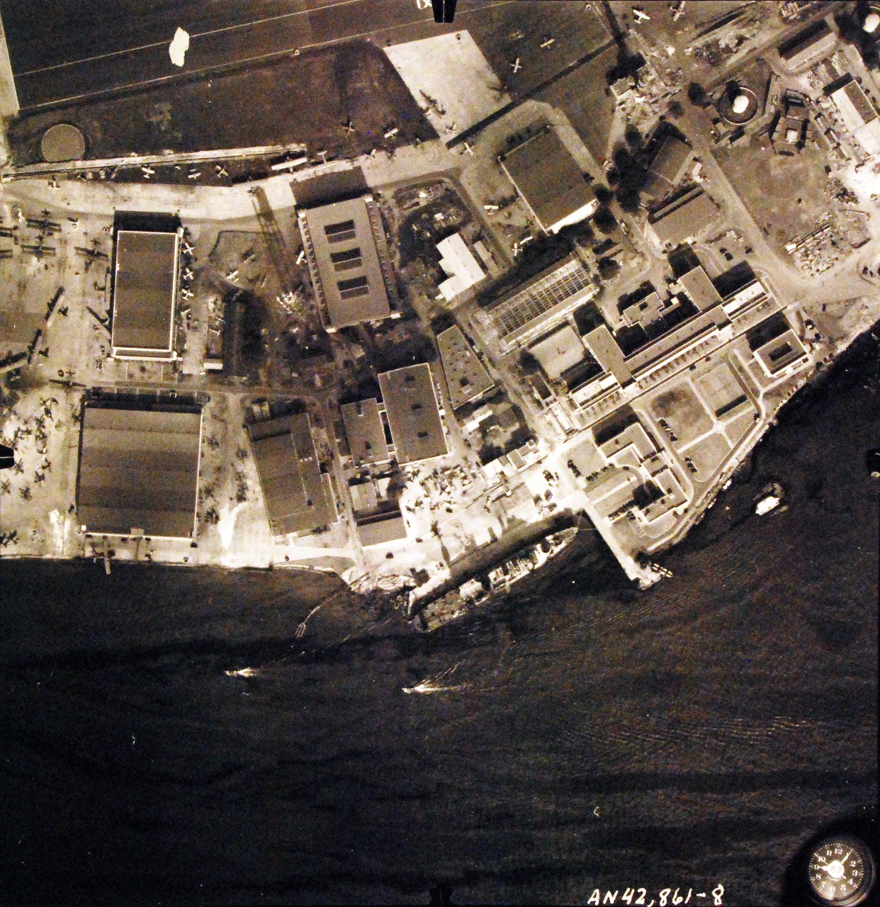 80-G-387569:  Pearl Harbor Attack, 7 December 1941.  Aerial view of "Battleship Row" moorings on the southern side of Ford Island, 10 December 1941, showing damage from the Japanese raid three days earlier.  USS Curtiss (AV 4) is shown.  Note dark oil streaks on the harbor surface, originating from the sunken battleships.  Photographed by VJ-1 at an altitude of 3,000 feet and released November 9, 1950. U.S. Navy photograph, now in the collections of the National Archives.   (9/22/2015).
