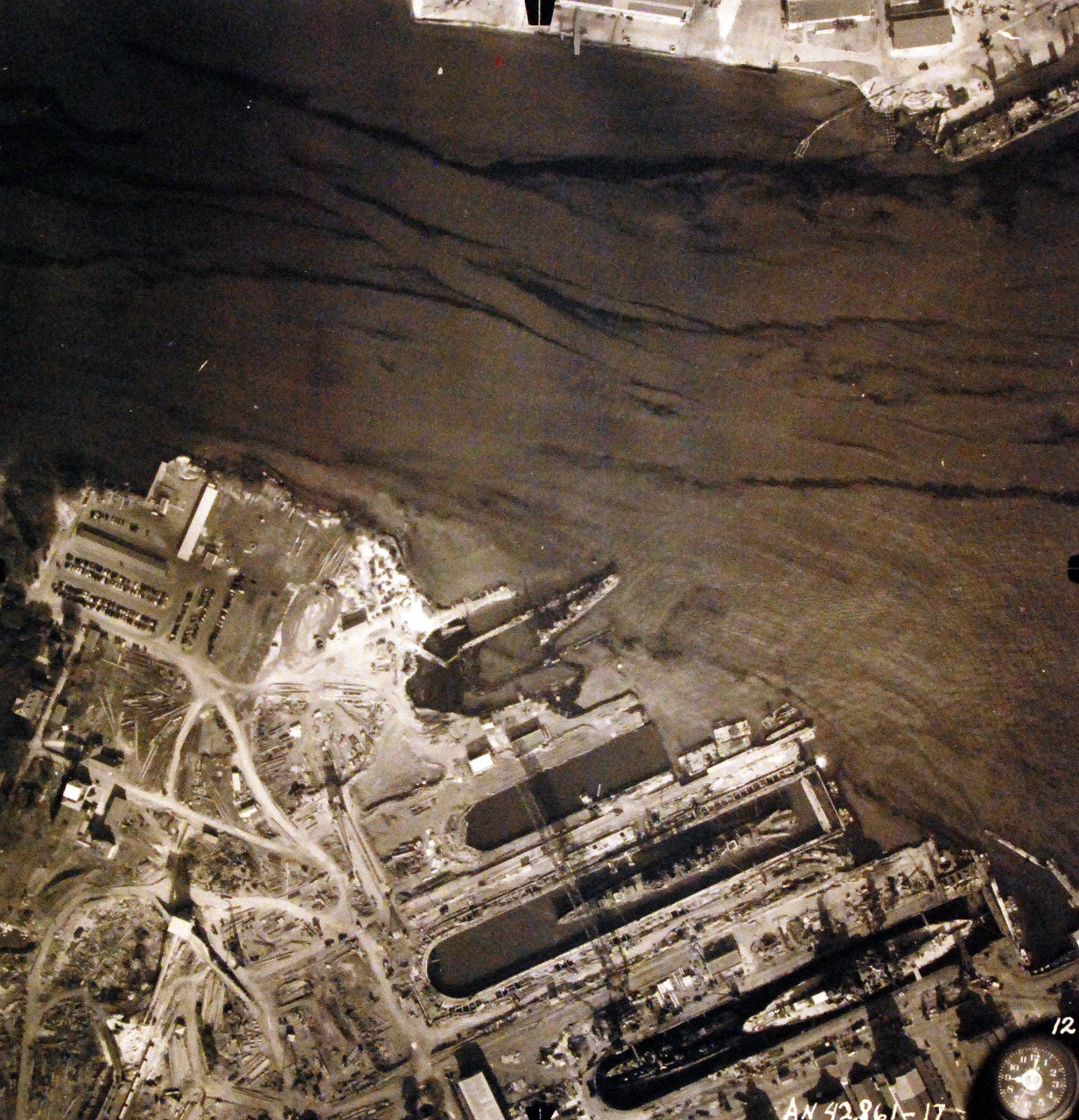 80-G-387578:  Pearl Harbor Attack, 7 December 1941.  Aerial view of "Battleship Row" moorings on the southern side of Ford Island, 10 December 1941, showing damage from the Japanese raid three days earlier.  Ships shown are, (right to left):  USS Pennsylvania (BB 38); USS Cassin (DD 372); USS Downes (DD 375); USS Helena (CL 50) and USS Shaw (DD 373).  Note dark oil streaks on the harbor surface, originating from the sunken battleships. Photographed by VJ-1 at an altitude of 3,000 feet and released November 9, 1950. U.S. Navy photograph, now in the collections of the National Archives.      (9/22/2015).