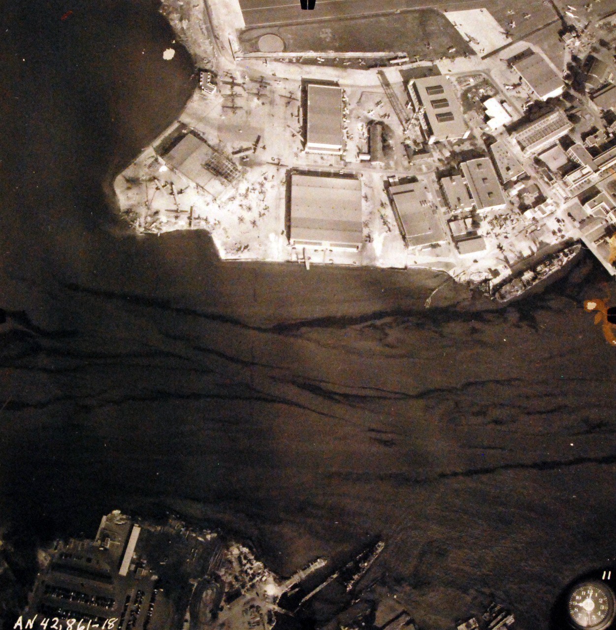 80-G-387579:  Pearl Harbor Attack, 7 December 1941.  Aerial view of "Battleship Row" moorings on the southern side of Ford Island, 10 December 1941, showing damage from the Japanese raid three days earlier.  Shown are USS Shaw (DD 373) and view of Naval Air Station Ford Island.  Note dark oil streaks on the harbor surface, originating from the sunken battleships. Photographed by VJ-1 at an altitude of 3,000 feet and released November 9, 1950. U.S. Navy photograph, now in the collections of the National Archives.       (9/22/2015).