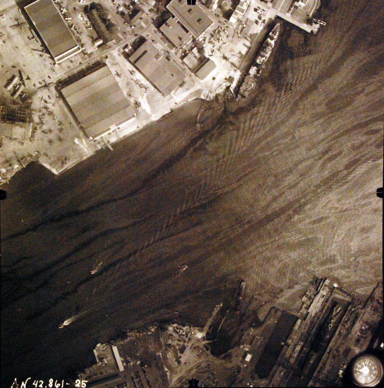 80-G-387586:  Pearl Harbor Attack, 7 December 1941.  Aerial view of "Battleship Row" moorings on the southern side of Ford Island, 10 December 1941, showing damage from the Japanese raid three days earlier.  Ship shown USS Curtiss (AV 4).  Note dark oil streaks on the harbor surface, originating from the sunken battleships. Photographed by VJ-1 at an altitude of 3,000 feet and released November 9, 1950. U.S. Navy photograph, now in the collections of the National Archives.     (9/22/2015).