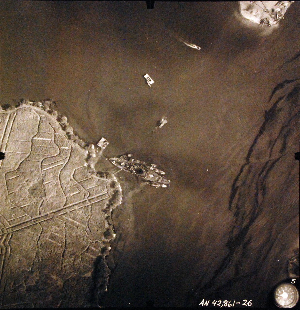 80-G-387587:  Pearl Harbor Attack, 7 December 1941.  Aerial view of "Battleship Row" moorings on the southern side of Ford Island, 10 December 1941, showing damage from the Japanese raid three days earlier.  USS Nevada (BB 36) is shown off Waipaio Point. Photographed by VJ-1 at an altitude of 3,000 feet and released November 9, 1950. U.S. Navy photograph, now in the collections of the National Archives.      (9/22/2015).