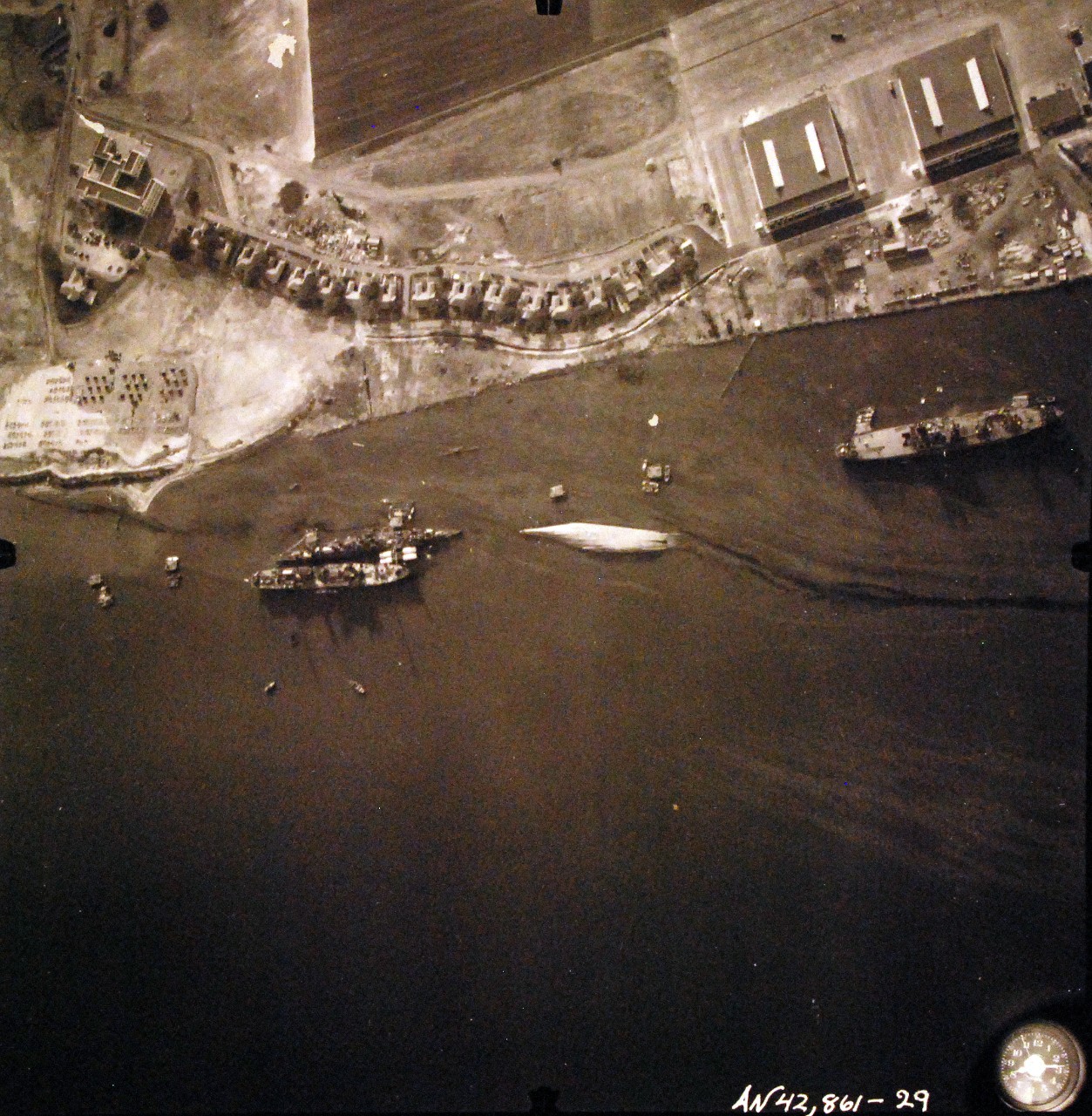 80-G-387590:  Pearl Harbor Attack, 7 December 1941.  Aerial view of "Battleship Row" moorings on the southern side of Ford Island, 10 December 1941, showing damage from the Japanese raid three days earlier.  Shown are USS Raleigh (CL 7), sunk, and USS Utah (BB 31), capsized.  Note dark oil streaks on the harbor surface, originating from the sunken battleships. Photographed by VJ-1 at an altitude of 3,000 feet and released November 9, 1950. U.S. Navy photograph, now in the collections of the National Archives.        (9/22/2015).