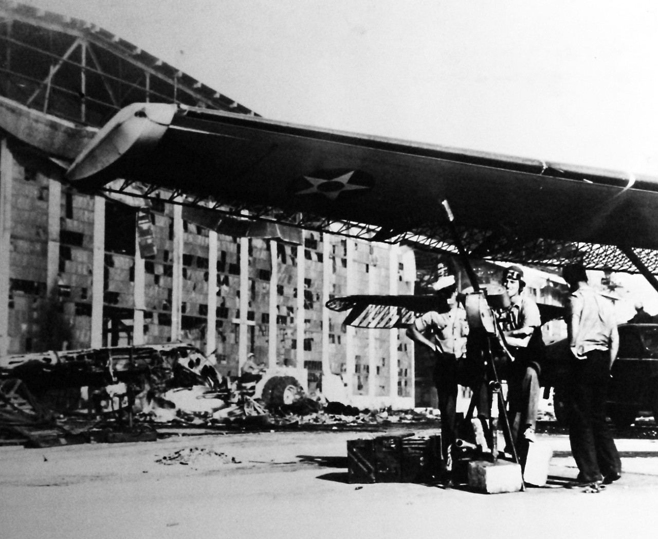 80-G-32895:  Japanese Attack on Pearl Harbor, December 7, 1941.   US Navy patrol plane and gun crew with improvised mount, made of pipe, in front of hangar at Ford Island, Naval Air Station, Pearl Harbor.  Official U.S. Navy photograph, now in the collections of the National Archives.   (8/27/2013).