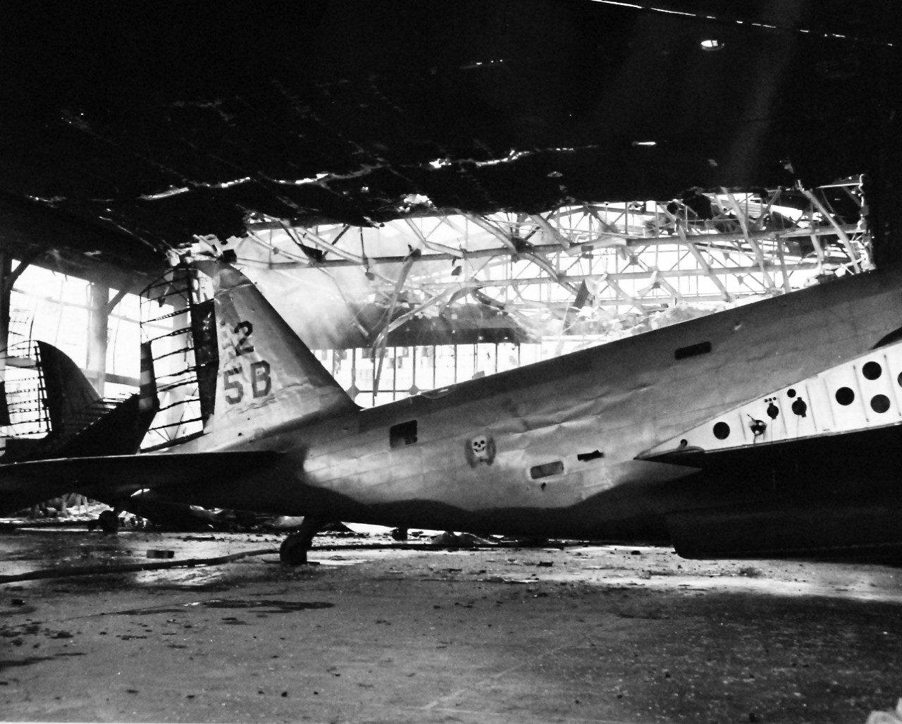 80-G-32904:  Japanese Attack on Pearl Harbor, December 7, 1941.    Damaged hangar and plane at Pearl Harbor, 7 December 1941.  Official U.S. Navy photograph, now in the collections of the National Archives.    (8/27/2013).