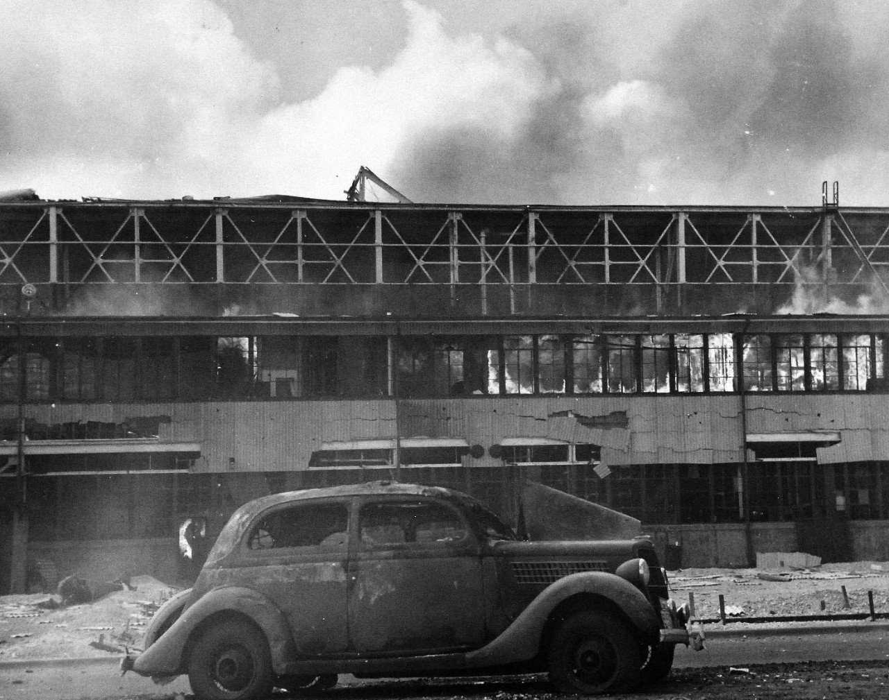 80-G-77652:   Japanese Attack on Pearl Harbor Attack, 7 December 1941.  Smoldering U.S. Navy Hangar at Naval Air Station, Kaneohe Bay, Oahu, after  Japanese attack.  Note, the wrecked automobile. U.S. Navy photograph, now in the collections of the National Archives (3/4/2015).