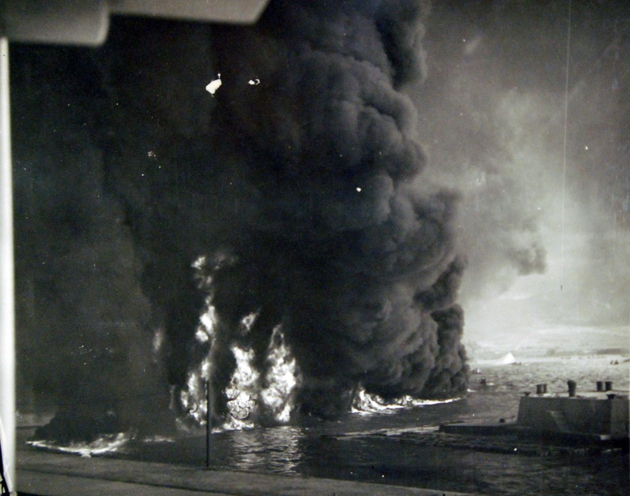 80-G-32579:  Japanese Attack on Pearl Harbor, December 7, 1941.   Oil burning on water near Naval Air Station boat landing after the Japanese raid on Pearl Harbor, Territory of Hawaii.  Official U.S. Navy photograph, now in the collections of the National Archives.     (7/2/2014).