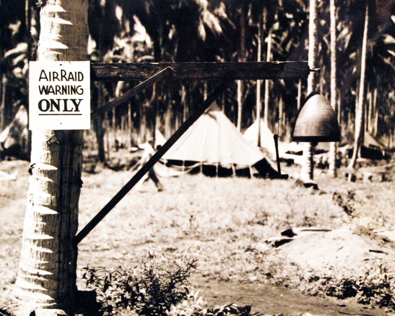 80-G-43756:  Guadalcanal, Solomon Islands.   The former nose piece of an enemy 14” shell which feel on Henderson Field, Guadalcanal, during a bombardment, is used as an alarm gong against raids.  Photograph released November 16, 1943.   Official U.S. Navy Photograph, now in the collections of the National Archives.    (2015/10/13).