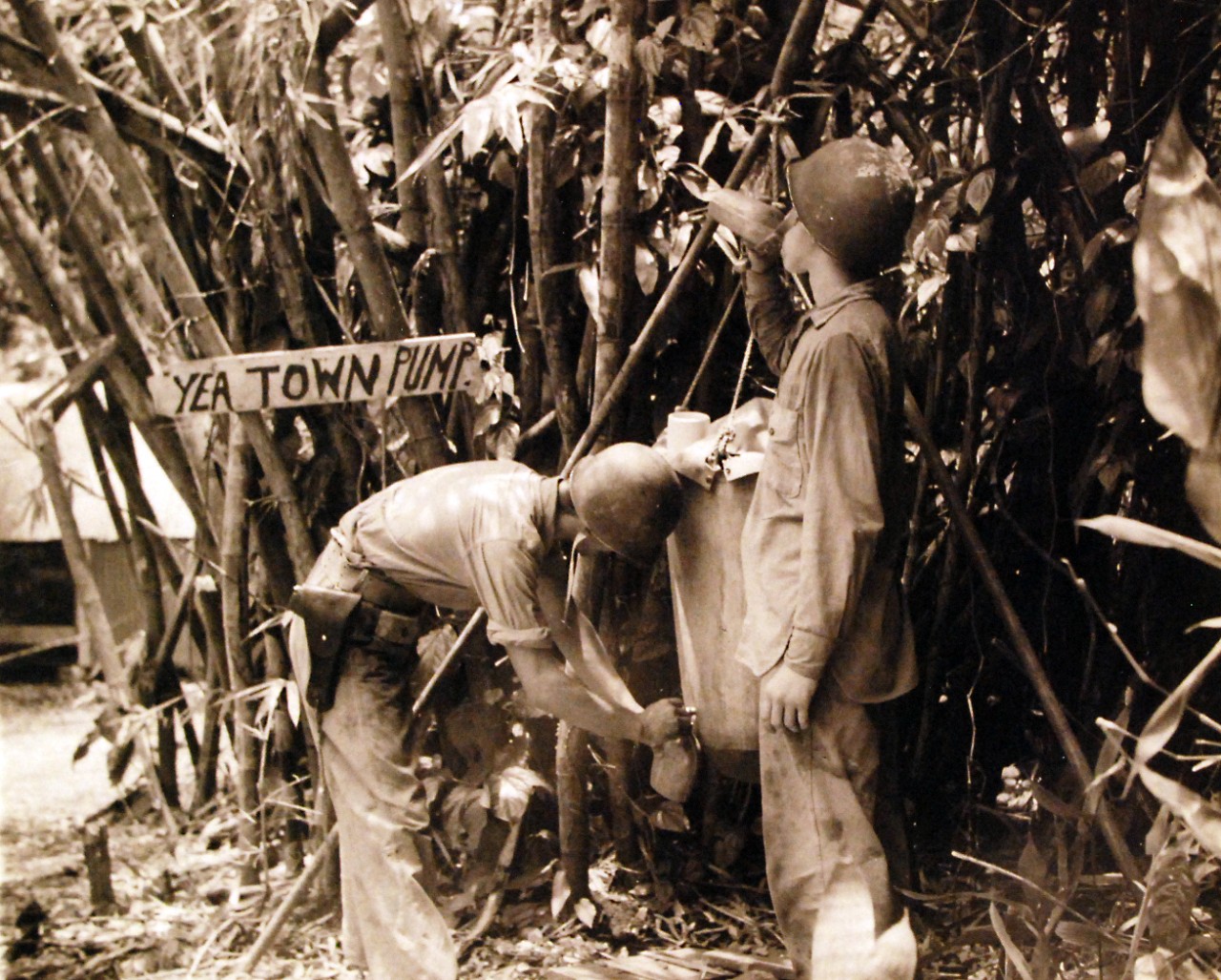 80-G-39213: Guadalcanal Campaign, August 1942-February 1943.  U.S. Marines get a drink from the lister bag, Marine Camp, Guadalcanal, January 30, 1943.  Note sign that reads, “Yea Town Pump.”  Official U.S. Navy photograph, now in the collections of the National Archives.  (2016/12/06).