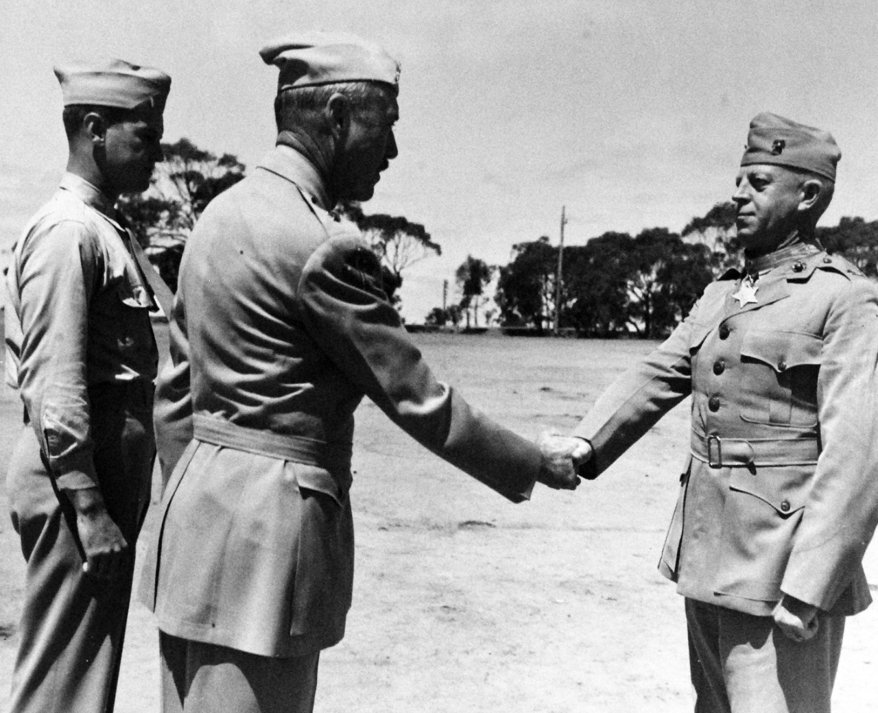80-G-43481:  Present of Awards by Brigadier General William H. Rupertus, USMC, Assistant Division Commander of the 1st Marine Division.  Colonel Merritt Austin Edson, USMC, wearing the Congressional Medal of Honor, awarded for his extraordinary heroism in combat at Guadalcanal  13-14 September 1942.   .  He shown being congratulated by Brigadier General Rupertus.  On the left is Lieutenant Guy Tarrant.    Note, during the early landing stages, Colonel Edson also received two Navy Crosses for his “extraordinary heroism”.    Official U.S. Navy Photograph, now in the collections of the National Archives.   Photograph released October 28, 1943.  (2015/08/18).