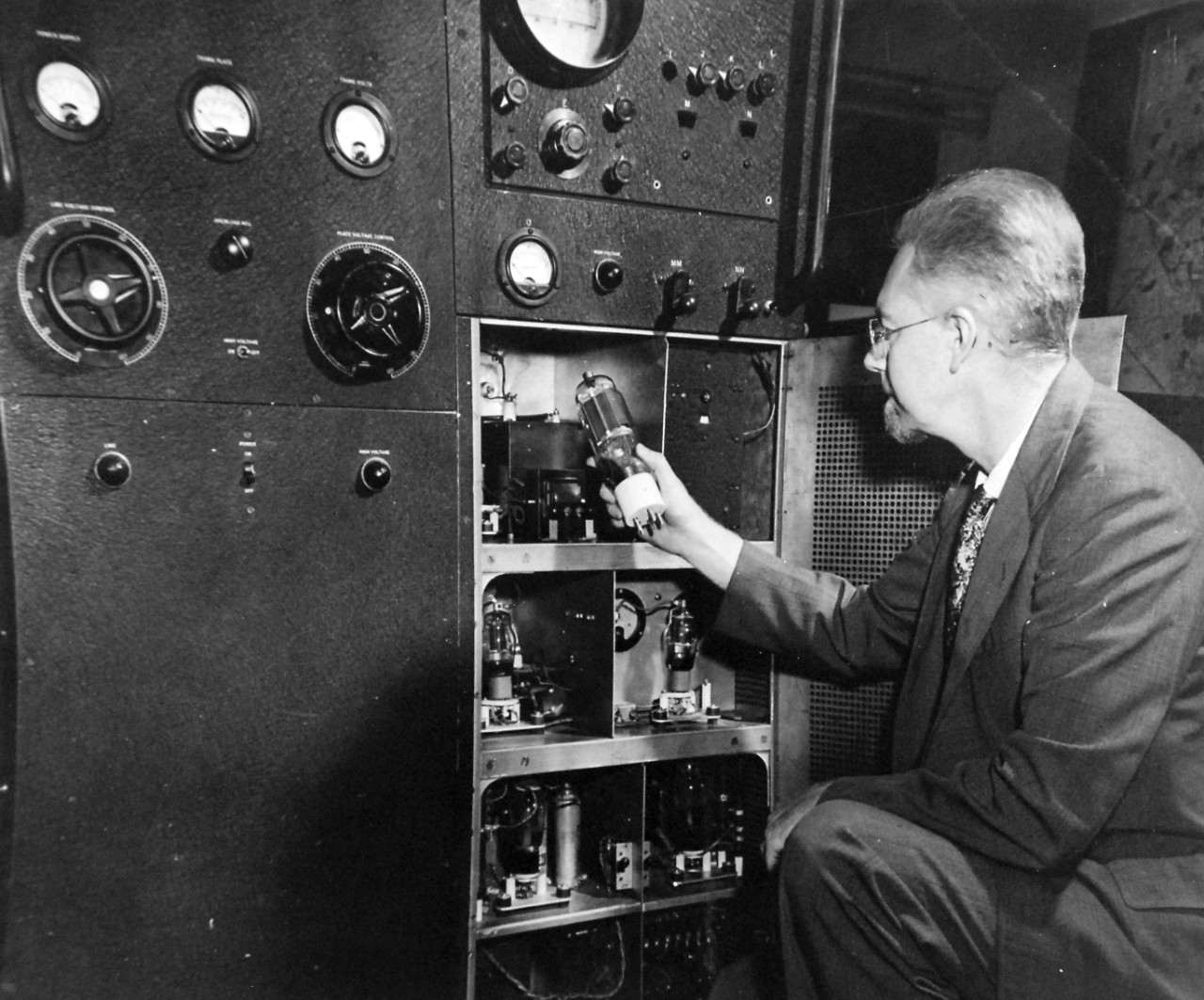 80-G-700312:  XAF Radar Receiver, 1930s.    Dr. Robert M. Page, pioneer in radar, examines one of the elemental radio tubes in the first radio set at Naval Research Laboratory in Anacostia, Washington, D.C.  Photograph released August 14, 1945.  U.S. Navy photograph, now in the collections of the National Archives.