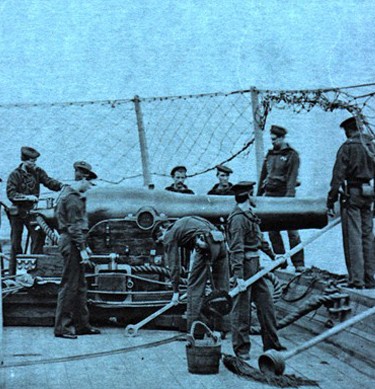 Photo of sailors surrounding a cannon. 