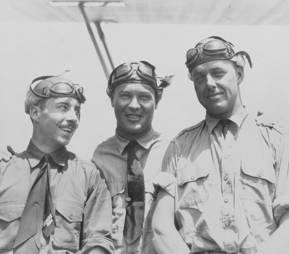 Three men in uniform with flight helmets.