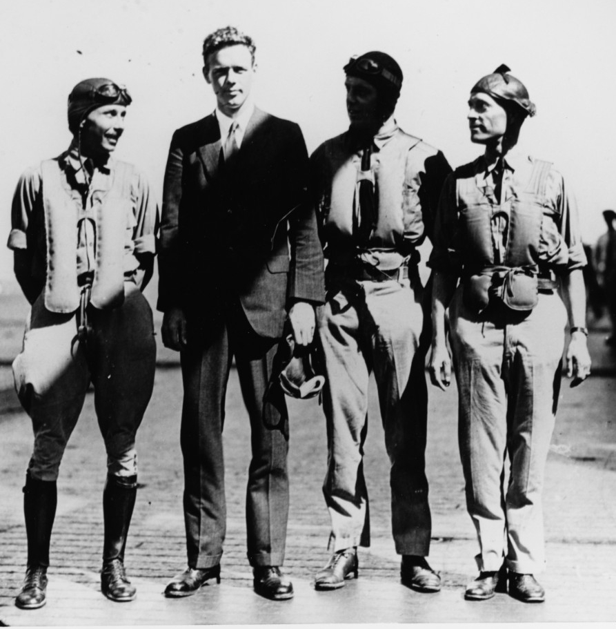 Four men standing side by side on a flight deck.